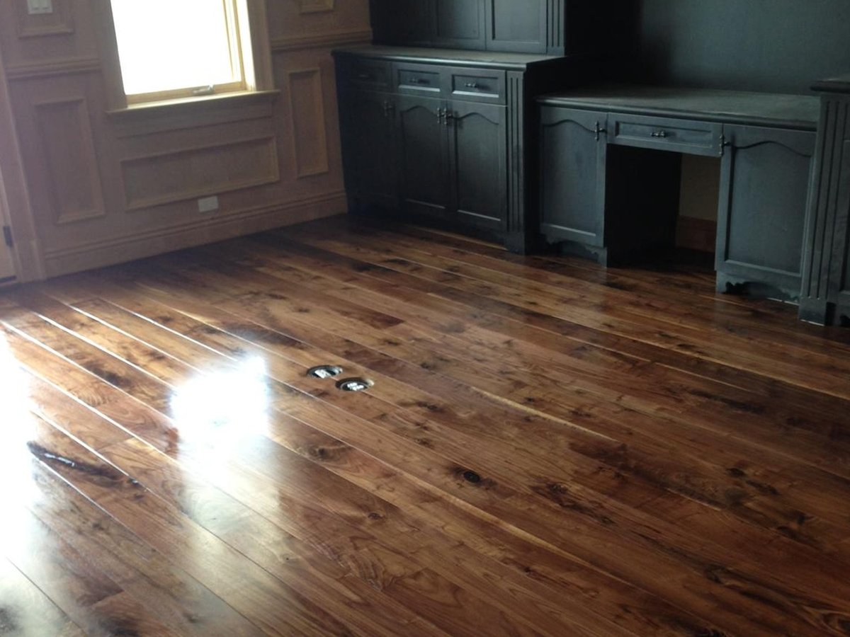 Completed Acacia Wood Floors residential project — refinished warm-tone hardwood floor with dark teal built-in cabinets