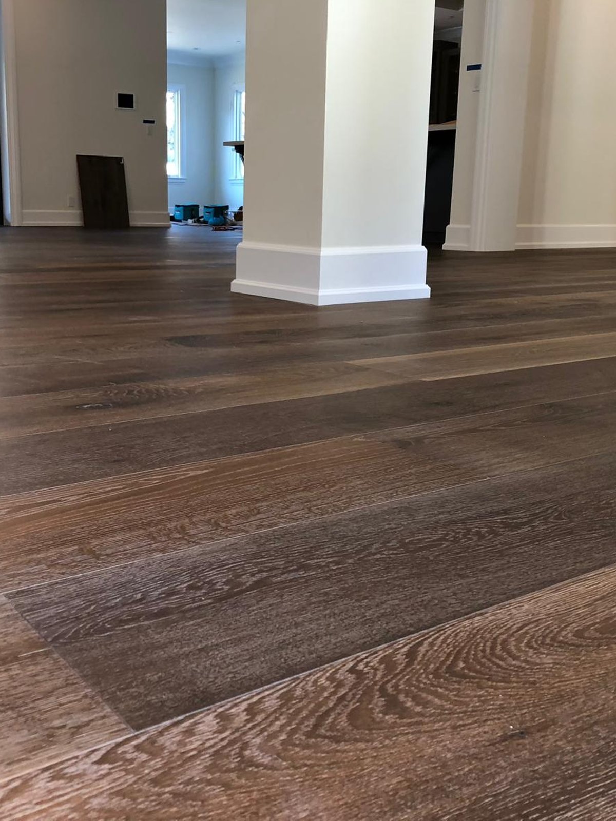 Completed Acacia Wood Floors project — wide-plank dark hardwood flooring with rich grain in a finished residential interior